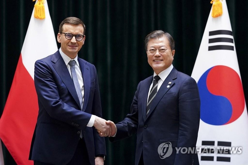 当地时间11月4日，在匈牙利布达佩斯，韩国总统文在寅（右）同波兰总理马泰乌什·莫拉维茨基在会谈前握手合影。 韩联社