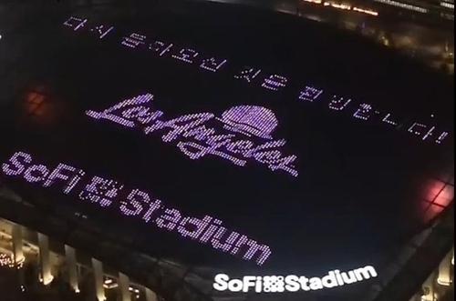 索菲体育场棚顶大屏幕用紫色标语欢迎阿米。 韩联社/索菲体育场推特视频截图（图片严禁转载复制）