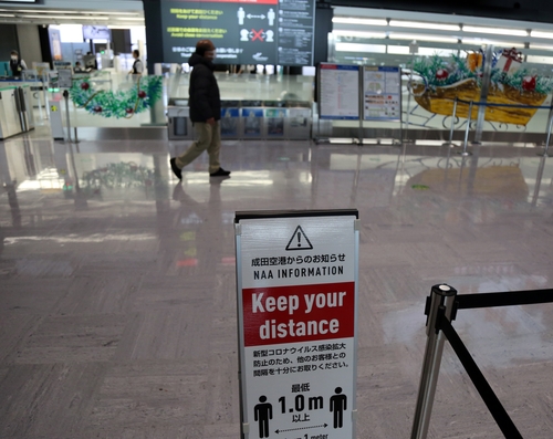 图为设置在日本成田机场的保持社交距离提示牌，摄于11月30日。 韩联社