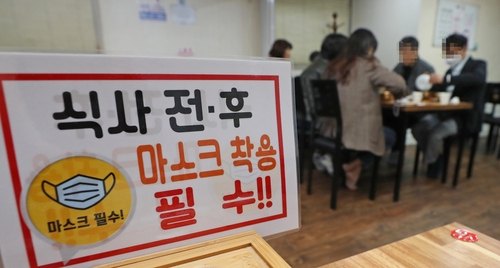 资料图片：餐厅内的佩戴口罩提示牌 韩联社