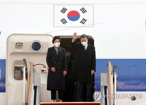 12月12日，在京畿道城南市的首尔机场，韩国总统文在寅（右）登机前向前来送行的人群挥手致意。文在寅当天起将对澳大利亚进行为期四天的访问。 韩联社