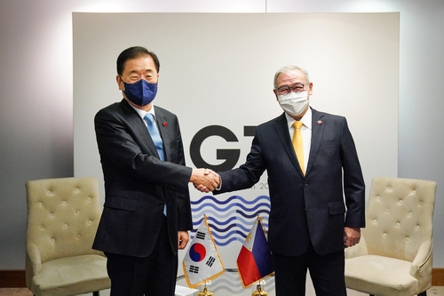 当地时间12月12日，在英国利物浦，韩国外交部长官郑义溶郑义溶（左）与菲律宾外长洛钦握手合影。 韩国外交部供图（图片严禁转载复制）