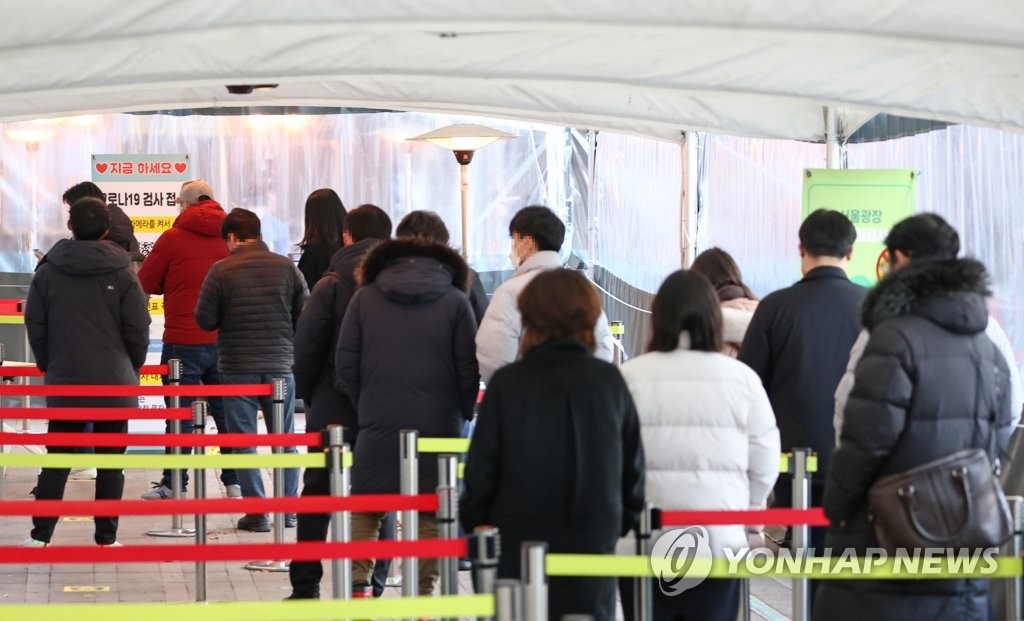 资料图片：12月30日，在设于首尔广场的新冠筛查诊所，市民排长队等待接受核酸检测。 韩联社