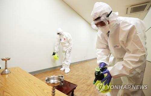 资料图片：防疫人员对殡仪馆进行防疫消毒。 韩联社