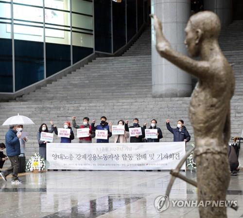 资料图片：在位于首尔市的地铁荣山站，韩国民间团队参谒象征二战时期被日方强征的韩籍劳工铜像（右边），并举行记者会。 韩联社