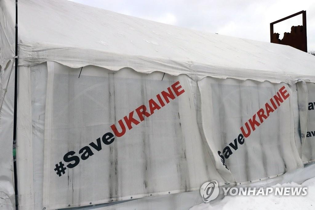 资料图片：当地时间1月18日，在乌克兰首都基辅独立广场，帐篷帆布上印着拯救乌克兰的标语。 韩联社