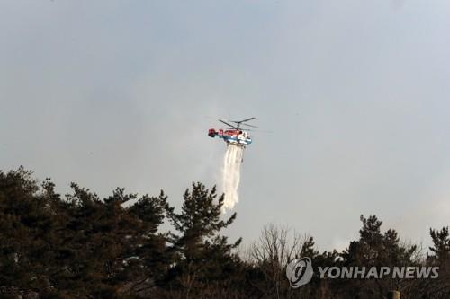 2月17日，在庆尚北道盈德郡盈德邑的山区，直升机正在洒水灭火。 韩联社