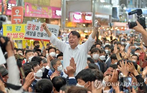资料图片：2021年9月17日，在庆尚北道浦项市竹岛市场，尹锡悦向支持者们振臂致意。 韩联社