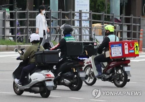 资料图片：2021年9月1日，在首尔，多名送餐员骑摩托车送餐。 韩联社