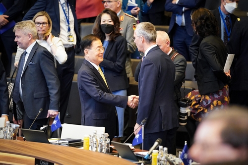 当地时间4月7日，在比利时布鲁塞尔，韩国外交部长官郑义溶（左）出席北约外长会议，同北约秘书长斯托尔滕贝格亲切握手。 韩联社/外交部供图（图片严禁转载复制）