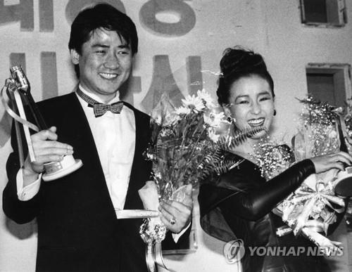 资料图片：1987年12月，姜受延（右）和演员李莹河荣获第26届大钟奖最佳主角奖后合影留念。 韩联社