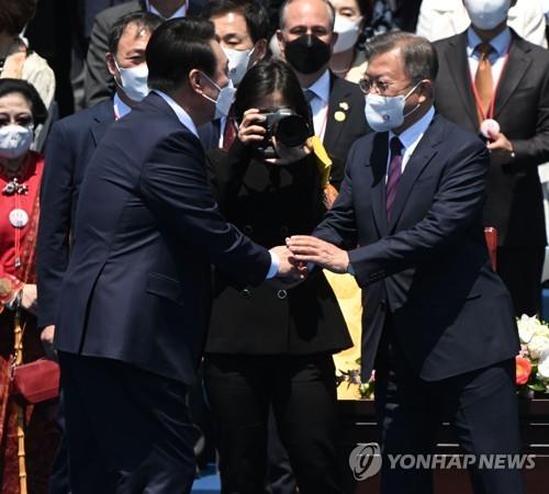 5月10日，在国会举行的总统就职典礼上，尹锡悦（左）与文在寅握手。 韩联社/国会摄影记者团供图（图片严禁转载复制）