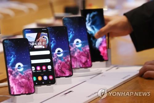 资料图片：2月14日，在位于首尔瑞草区的三星旗舰店，用户正在体验Galaxy S22系列智能手机。 韩联社