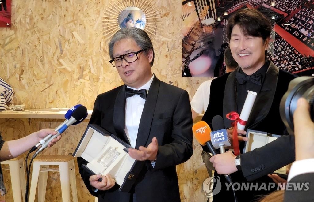当地时间5月28日，韩国演员宋康昊（右）和导演朴赞郁分获第75届戛纳国际电影节最佳男演员奖和最佳导演奖。图为二人在颁奖典礼结束后接受记者采访。 韩联社