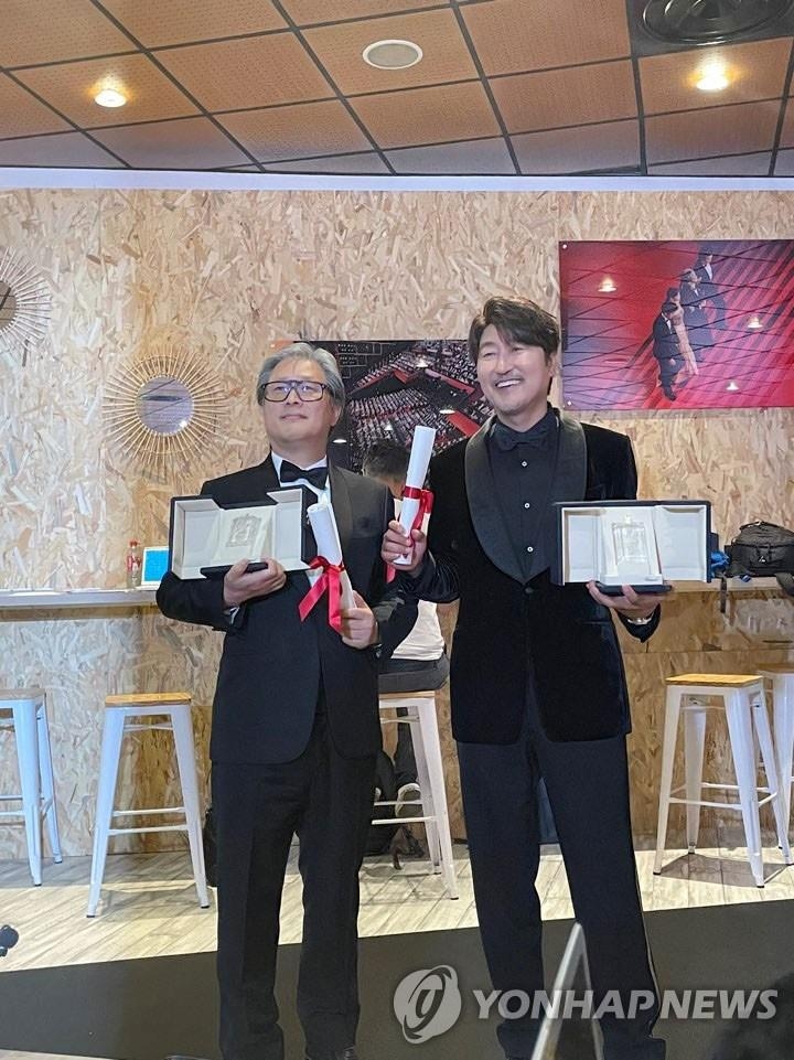 当地时间5月28日，韩国演员宋康昊（右）和导演朴赞郁分获第75届戛纳国际电影节最佳男演员奖和最佳导演奖。图为二人合影留念。 韩联社
