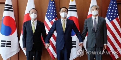 6月3日,在首尔钟路区的外交部大楼,韩国外交部韩半岛和平交涉本部长金健(中)同美国国务院对朝政策特别代表星·金(右)和日本外务省亚大局局长船越健裕举行三边会谈。图为三方在会谈开始前合影留念。 韩联社/联合记者团