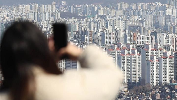 资料图片：一名市民从首尔南山远眺市区。 韩联社