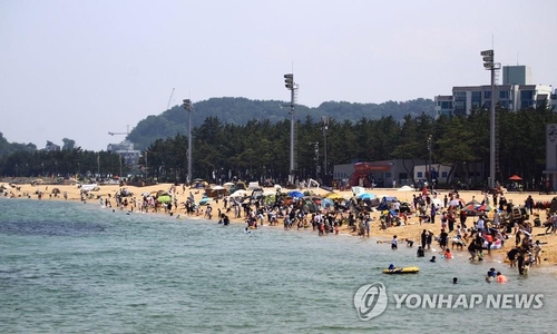 资料图片：6月9日，在束草海水浴场，不少市民和游客来到海边沙滩戏水，纳凉避暑。 韩联社