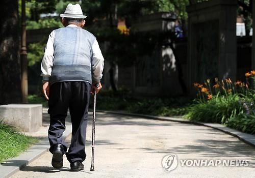 资料图片：2016年7月10日，一名老人在首尔塔谷公园行走。 韩联社