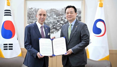 7月6日，在外交部大楼，第一次官赵贤东（右）和摩洛哥驻韩大使沙菲克·拉查迪互换两国外长贺信。 韩联社
