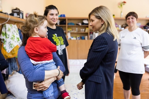 乌克兰第一夫人叶莲娜·泽连斯卡娅（右二）在庇护所与一名儿童交谈。 乌克兰总统办公室供图（图片严禁转载复制）