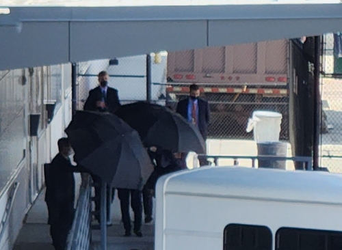 当地时间7月19日，韩国国家情报院院长金奎显抵达美国华盛顿杜勒斯国际机场。图为保安人员撑伞保密。 韩联社