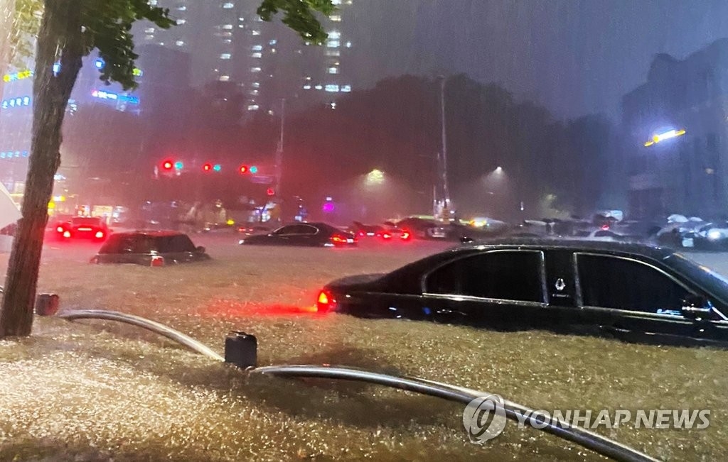 8月8日晚，首尔大峙站附近的道路被水淹没，车辆被困。 韩联社/读者供图（图片严禁转载复制）