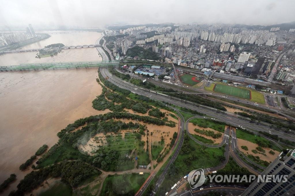 这是8月9日在首尔汝矣岛63大厦俯瞰的汉江和街景。首尔前一日遭受80年一遇的暴雨，导致汉江水位大涨。 韩联社