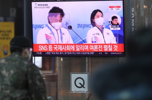 资料图片：2022年2月8日下午，在首尔市龙山站，市民收看报道短道速滑误判争议的新闻。 韩联社