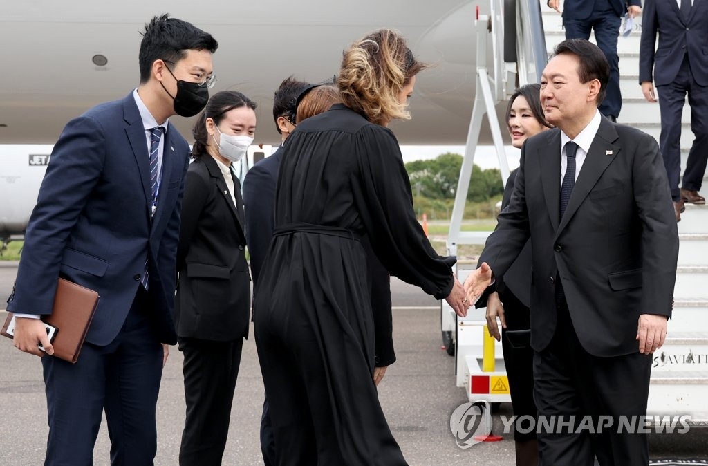 资料图片：当地时间9月18日，韩国总统尹锡悦（右）飞抵英国伦敦斯坦斯特德机场，开启为期七天的英美加三国访问之旅。图为尹锡悦与前来迎接的英方人士握手致意。 韩联社