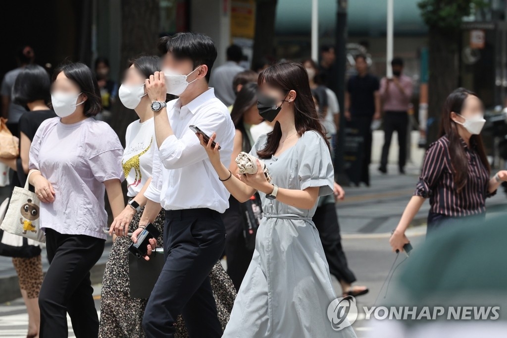 资料图片：民众佩戴口罩出行。 韩联社