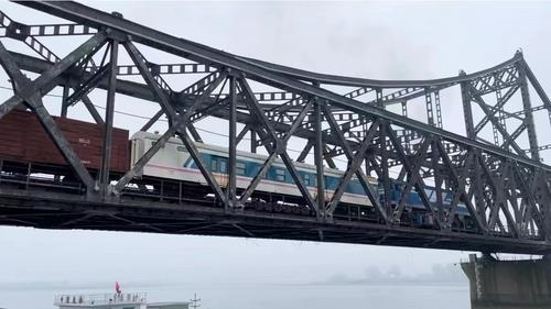 资料图片：9月27日，从中国丹东出发的货列经过中朝友谊桥（鸭绿江铁桥）开往朝鲜新义州。 韩联社