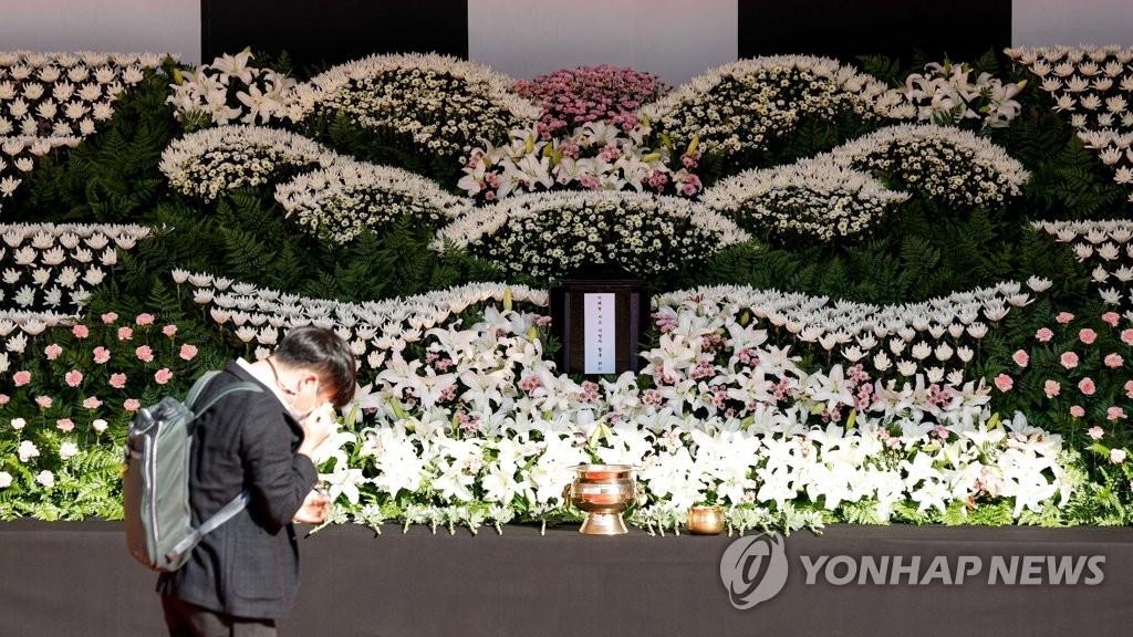 资料图片：10月31日，在设于首尔广场的梨泰院踩踏事故遇难者灵堂，一市民在献花致祭后潸然泪下。 韩联社/联合采访团