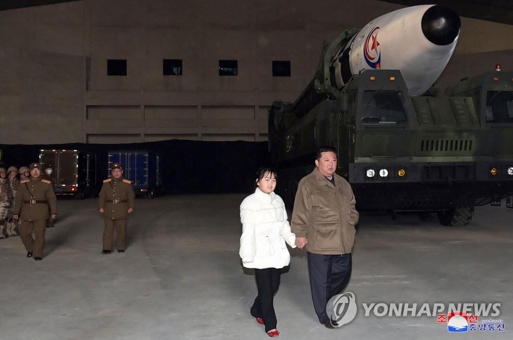 资料图片：据朝中社11月19日报道，朝鲜前一天在国务委员会委员长金正恩的指导下试射了“火星-17”型洲际弹道导弹。图为身穿白衣的女孩（左）牵着金正恩的手走过发射场。 韩联社/朝中社（图片仅限韩国国内使用，严禁转载复制）