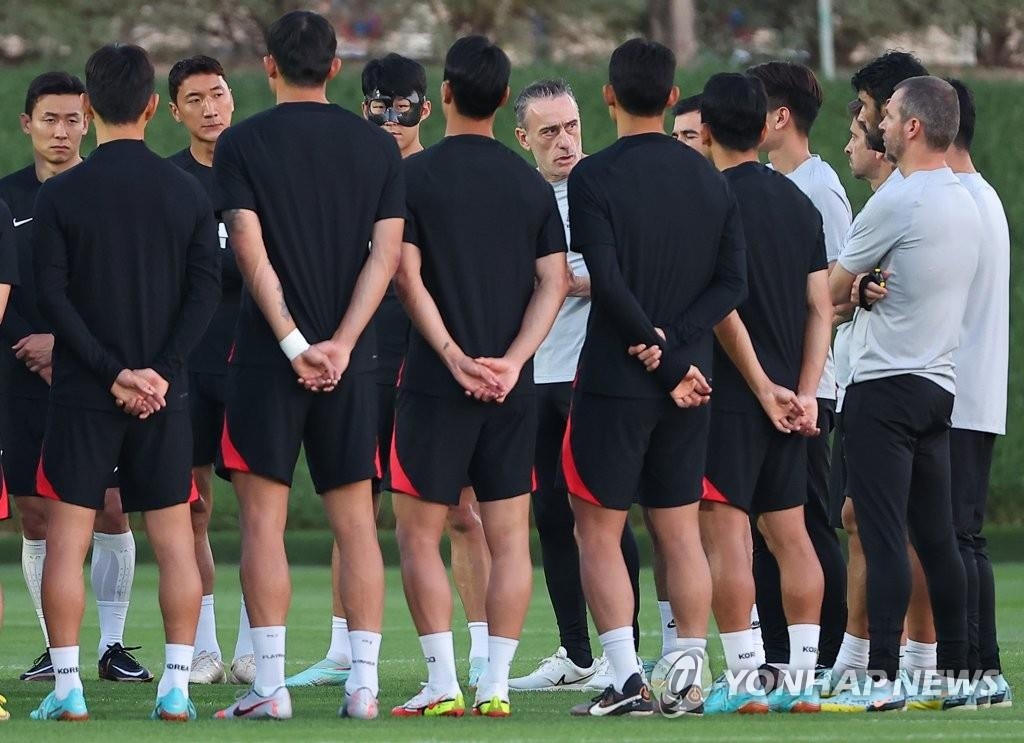 当地时间11月22日，在位于卡塔尔首都多哈的阿尔艾格拉训练场，韩国国足集训备战。图为韩国队主帅保罗·本托（左七）与队员们交谈。 韩联社