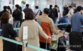 资料图片：出境游客排队办理登机手续。 韩联社