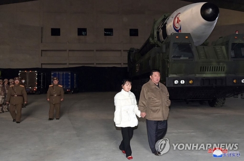资料图片：据朝中社11月19日报道，朝鲜前一天在国务委员会委员长金正恩（右）的指导下试射了“火星-17”新型洲际弹道导弹。报道还介绍称，金正恩携女儿和夫人亲临现场。这是朝媒首次报道金正恩女儿公开露面。图为身穿白衣的女孩牵着金正恩的手走过发射场。 韩联社/朝中社（图片仅限韩国国内使用，严禁转载复制）