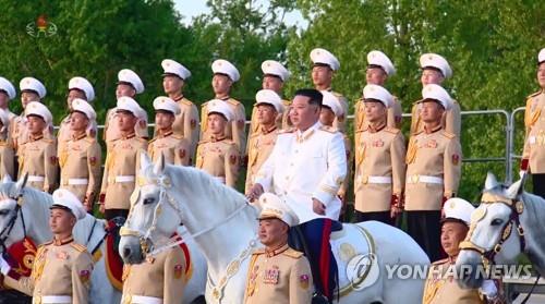 资料图片：4月27日，在朝鲜“建军”90周年纪念仪式上，金正恩（前排白衣）骑着白马与官兵合影。 韩联社/朝鲜央视画面截图（图片仅限韩国国内使用，严禁转载复制）