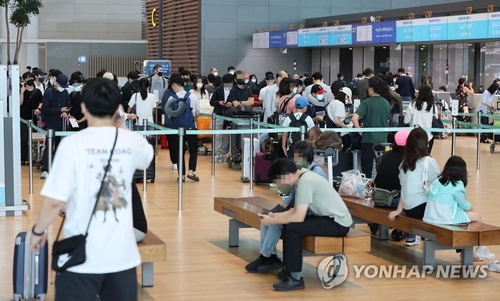资料图片：2022年9月14日，在仁川国际机场第二航站楼，旅客们正在排队等待办理登机手续。随着自海外入境韩国前核酸检测规定的废除，出国客流大增。 韩联社
