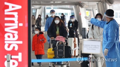 资料图片：1月5日，在仁川国际机场第一航站楼，自华入境旅客在防疫工作人员的指引下前往新冠筛查中心。 韩联社