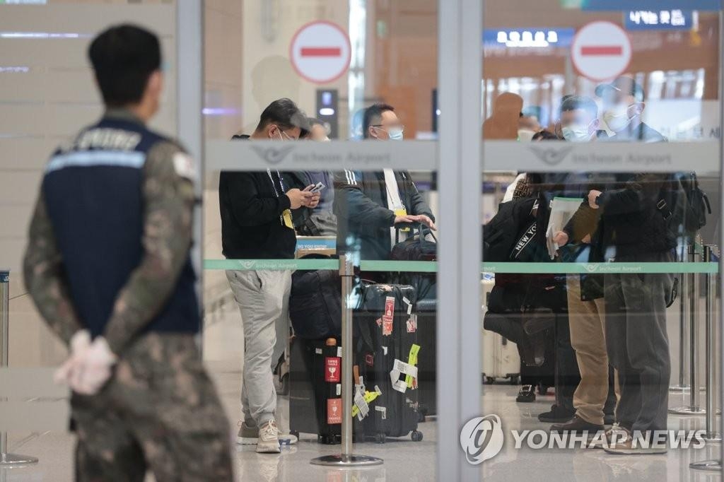 资料图片：1月9日上午，在仁川机场第二航站楼，来自中国的旅客聚集在到达大厅门口。 韩联社