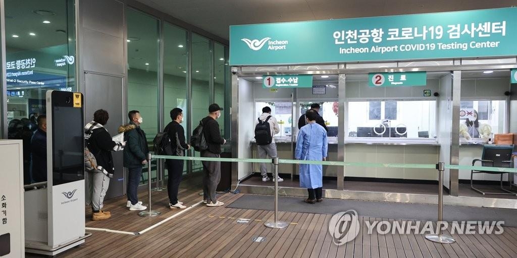 资料图片：1月9日，在仁川国际机场，自华入境人员前往新冠检测中心接受落地检。 韩联社