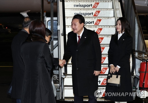 当地时间1月17日下午，韩国总统尹锡悦（右二）和夫人金建希乘坐总统专机“空军一号”飞抵苏黎世国际机场，与前来迎接的人士握手致意。 韩联社