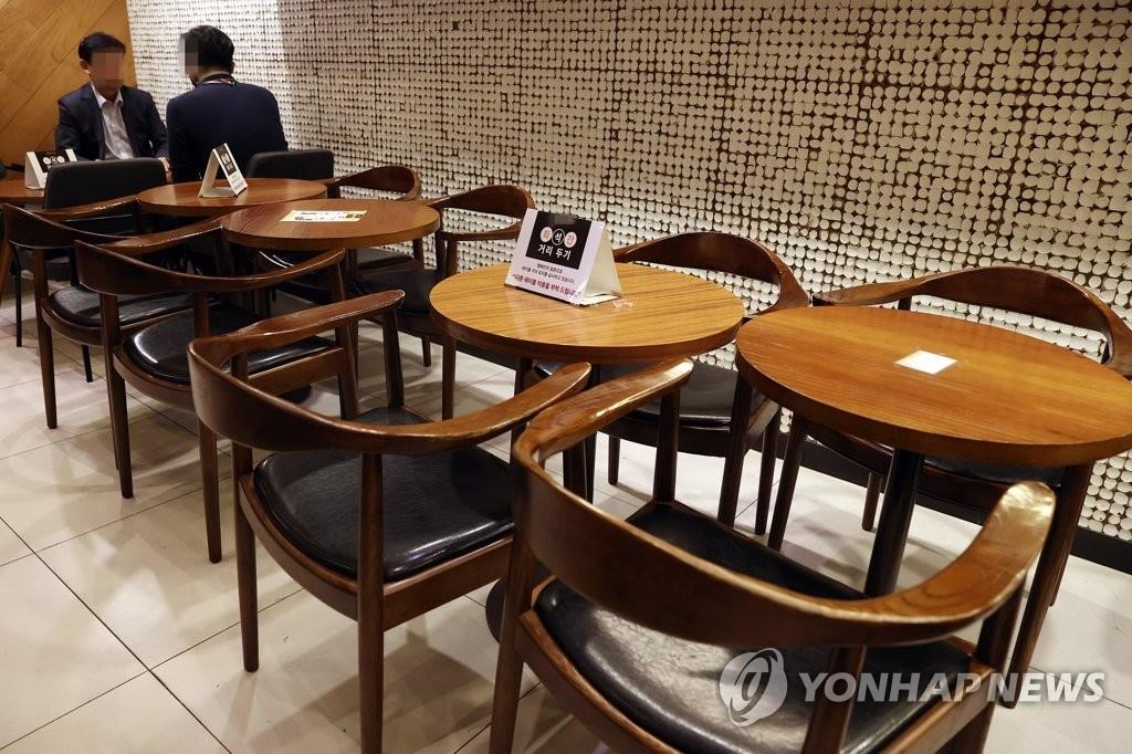 资料图片：2020年11月17日，首尔一家咖啡馆采取隔桌隔位就座等防疫措施。韩国政府当天表示，从19日零时起首都圈社交距离限制措施等级将提升至1.5级。 韩联社