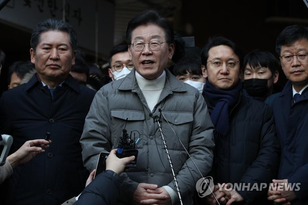 1月18日，在首尔麻浦区望远市场，李在明（居中）就遭检方传唤发表立场。 韩联社/联合记者团