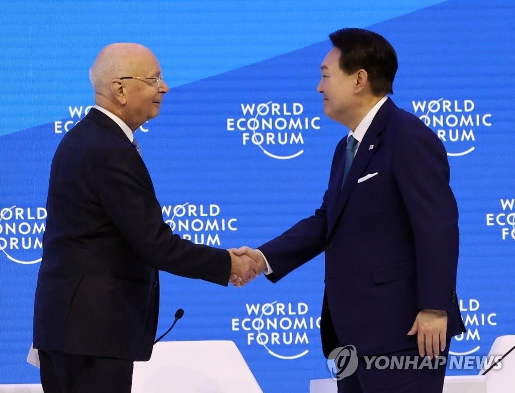 当地时间1月19日，在瑞士举行的世界经济论坛（达沃斯论坛）2023年年会上，韩国总统尹锡悦（右）同世界经济论坛主席克劳斯·施瓦布握手。 韩联社
