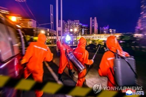 资料图片：朝中社2022年6月7日报道称，平壤市寺洞区的防疫工作人员在抗疫一线保持高度警惕，开展防疫作业。 韩联社/朝中社（图片仅限韩国国内使用，严禁转载复制）