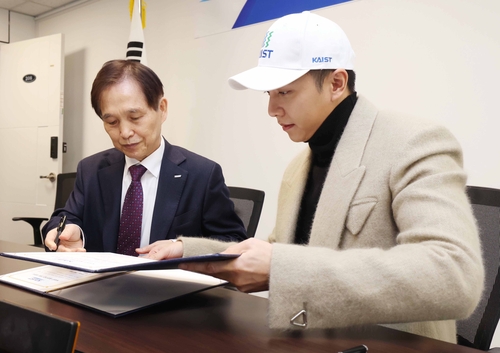 2月3日，韩国歌手兼演员李昇基（右）向韩国科学技术院校长李光炯传达3亿韩元的发展基金。 韩联社/KAIST供图（图片严禁转载复制）