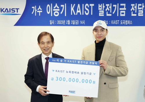 2月3日，韩国歌手兼演员李昇基（右）向韩国科学技术院（KAIST）校长李光炯传达3亿韩元（约合人民币164.8万元）的发展基金。 韩联社/KAIST供图（图片严禁转载复制）
