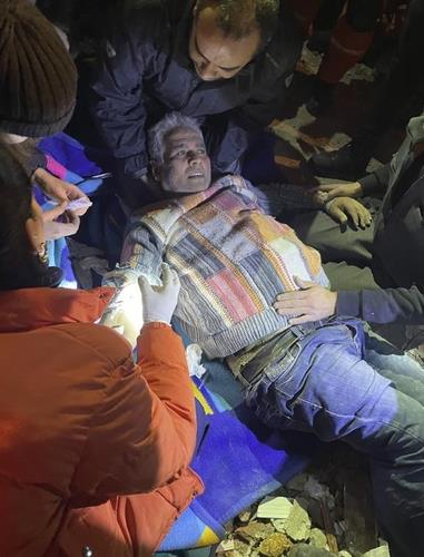 韩国救援队救出地震幸存者。 韩联社/紧急救援队供图（图片严禁转载复制）